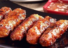 some food is on a black plate near other plates with different types of foods in them