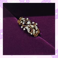 a gold and diamond ring sitting on top of a purple cloth