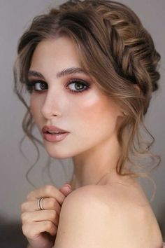 a woman with braid hair and ring on her left hand posing for the camera, wearing an off shoulder dress