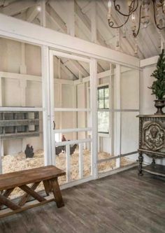 an empty room with a bench in front of the glass doors that lead to another room