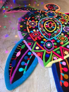 brightly colored rugs on the floor with lights in the background