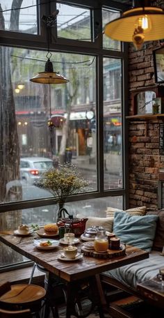 a table with food on it sitting in front of a large window that looks out onto the street