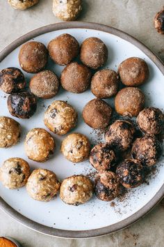 a white plate topped with lots of different types of cookies and muffins on top of a table