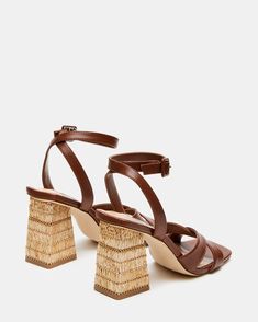 These RENLEY sandals feature a playful criss cross front strap and a sturdy block heel . Its raffia heel adds a unique touch, while the ankle strap ensures a comfortable fit. Perfect for adding a fun and quirky twist to your summer outfits!  3.5 inch heel height Leather upper material Synthetic lining Synthetic sock Synthetic sole Imported Brown Open Toe T-strap Sandals With Leather Strap, Brown T-strap Sandals With Block Heel And Buckle, Brown Synthetic Open Toe T-strap Sandals, Brown Ankle Strap Synthetic T-strap Sandals, Brown Strappy T-strap Sandals With Buckle Closure, 5 Inch Heels, Womens Heels, Criss Cross, Block Heels