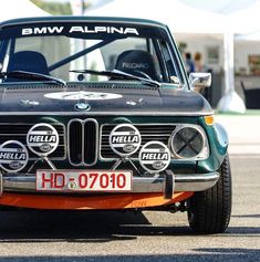 an old bmw is parked on the street