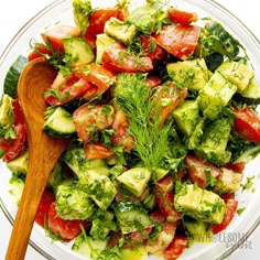 a salad with cucumbers, tomatoes and other vegetables