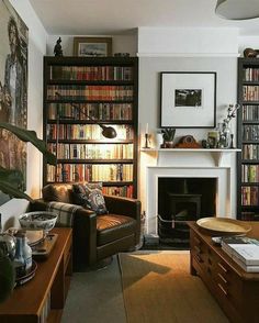 a living room filled with furniture and a fire place in front of a book shelf