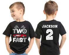 two boys wearing black shirts with cars and numbers on the front, one boy has his hands in his pockets