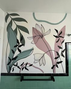 a green tiled bathroom with floral wall mural