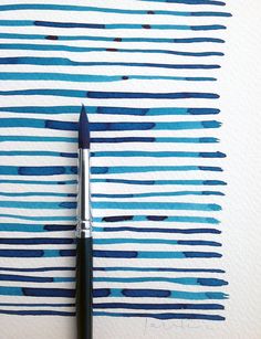 a pen is sitting on top of a piece of paper that has been painted blue and white