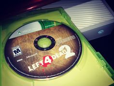 a video game disc sitting on top of a green plastic case with the words let's 4 dead written on it