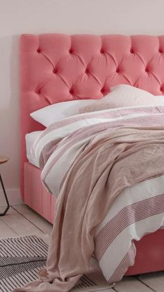 a bed that has a pink headboard on it