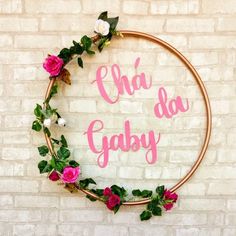 a sign that says cha da gaby with flowers around it on a brick wall