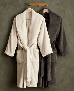 two robes hanging on a wall next to each other