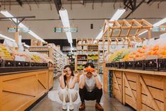 two people are kneeling down in the aisle of a grocery store and posing for a photo