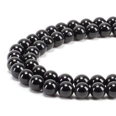 a black beaded necklace on a white background