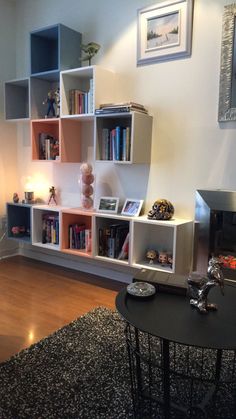 a living room filled with furniture and bookshelves next to a fire place on top of a hard wood floor