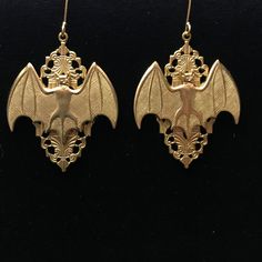 Large Victorian style filigree drops with a gold brass bat hang from a gold filled French hook earring. The stamped, raw brass, open work components have great detail. These are kind of heavy since the 1.25 x .75 inch bats are cast brass. They also have nice detail including eyes, ears, muzzle and hatch marks on the wings. They drop to about 2 inches.  Please note that raw brass will oxidize over time, diminishing the brightness and giving it a natural antique darkening of the gold color. This piece of jewelry is sent in a bubble pack envelope via US postal service, first class mail with insurance and packed in a gift box. International rate is $23. Buyers are responsible for any customs and import taxes that may apply. These fees are taken by your country, not Etsy. Necromance is not resp Handmade Gothic Gold Earrings, Gothic Gold Filigree Jewelry, Gothic Gold Brass Earrings, Gold Gothic Brass Earrings, Gold Gothic Jewelry, Alternative Wedding Inspiration, Bat Jewelry, Earrings Gothic, Bat Earrings