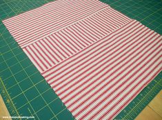 a cutting board with red and white strips on it next to a green cutting mat