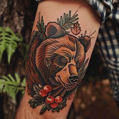 a man with a bear tattoo on his arm holding a pine cone and berry bush