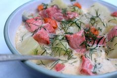 a bowl filled with meat and vegetables on top of a blue table cloth next to a spoon