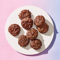 a white plate topped with chocolate cookies on top of a pink table