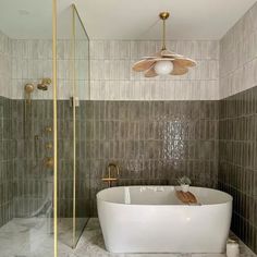 a bath tub sitting under a ceiling fan in a bathroom next to a walk in shower