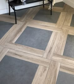 a cat is sitting on a bench in the middle of a room with tile flooring