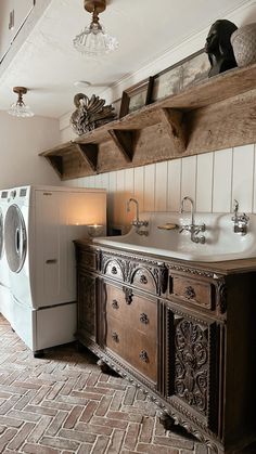 a washer and dryer in a bathroom with wooden shelves above it's sink