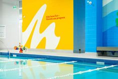 an indoor swimming pool with blue and yellow walls