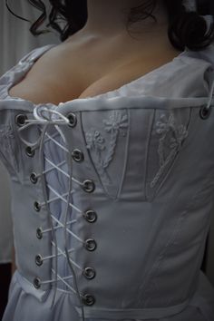 -------------------Corset------------------ This historical corset is made with steel boning and canvas layered with white cotton twill fabric. The cups have flower decorations for an intimate feel. ----------------Sizing------------------- Please reference the last slide for measurements. Use the bust measurements when ordering. For a custom fit please provide the following measurements: bust underbust -------------SHIPPING------------ Please allow 4-6 weeks for the corset to be made and shippe