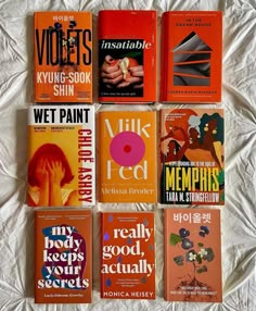 there are many books on the bed together, all in different colors and font choices