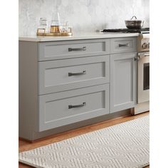 a kitchen with gray cabinets and white counter tops