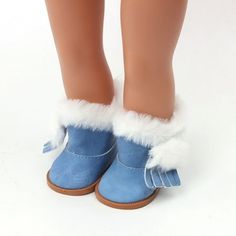 a doll's legs wearing blue shoes with white fur trims and tassels