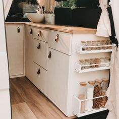 a kitchen with white cabinets and wooden floors