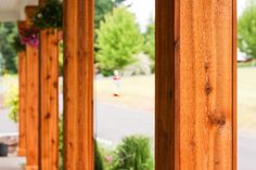 the porch is lined with wooden pillars and flowers