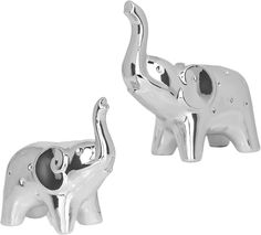 two silver elephant figurines sitting next to each other on top of a white surface