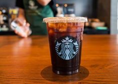 a starbucks drink sitting on top of a wooden table