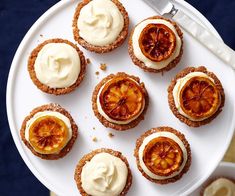 a white plate topped with mini desserts covered in icing and orange zest