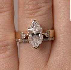 a woman's hand with a ring that has a large diamond in the center