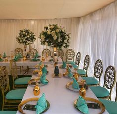 a dining room set up with green chairs and white table cloths, gold trimmings and floral centerpieces