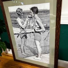 two women standing next to each other holding tennis racquets in their hands