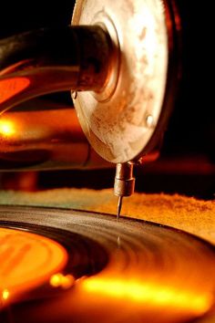 a close up of a turntable with some metal in the foreground and light shining on it