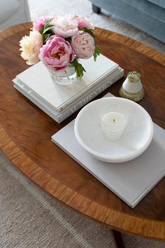 a coffee table with flowers in a vase on it