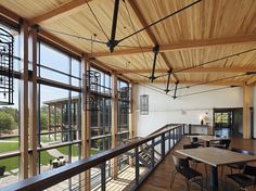 the inside of a large building with lots of windows and wooden flooring on both sides