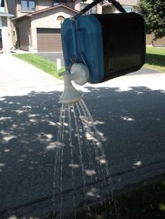 a blue suitcase being sprinkled with water from a hose attached to a pole