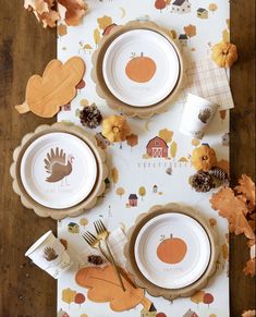 the table is set for thanksgiving dinner with plates and napkins