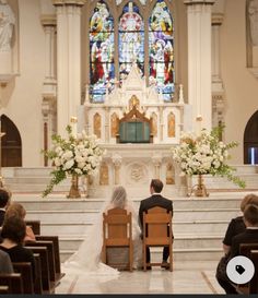 the bride and groom are sitting at the alter