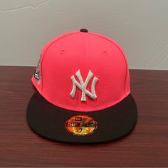 a new york yankees hat sitting on top of a wooden table next to a wall