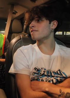 a young man sitting in the back seat of a car